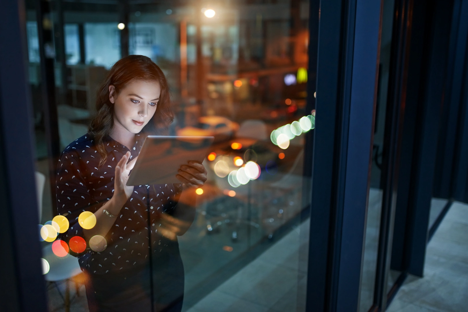 Cropped shot of a young businesswoman working late on a digital tablet in an office