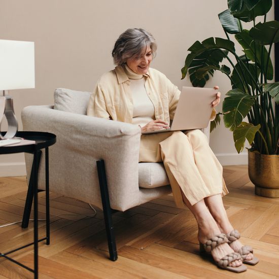 Woman sitting on a chair with a laptop on her lap
