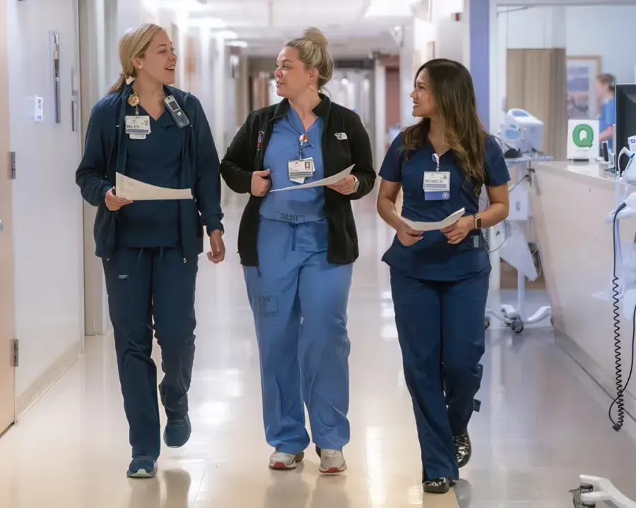Doctors and nurses walking down a hospital corridor and talking to each other