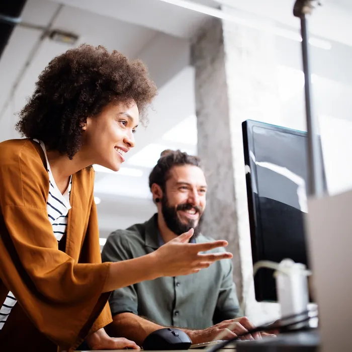 Woman looking at computer screen with a man next to her