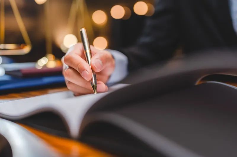 Close up of a man writing in a notepad