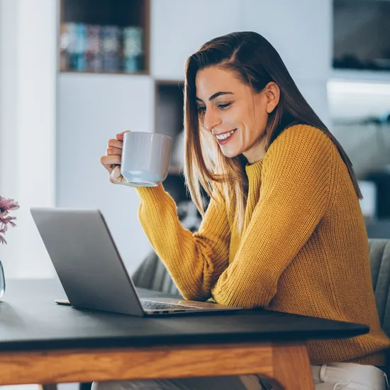 Young woman working at home, typing on laptop