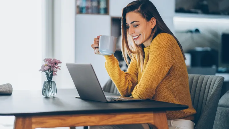 Young woman working at home, typing on laptop