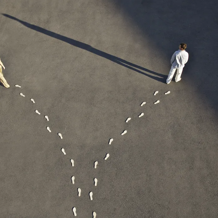 Man and woman with diverging line of footprints