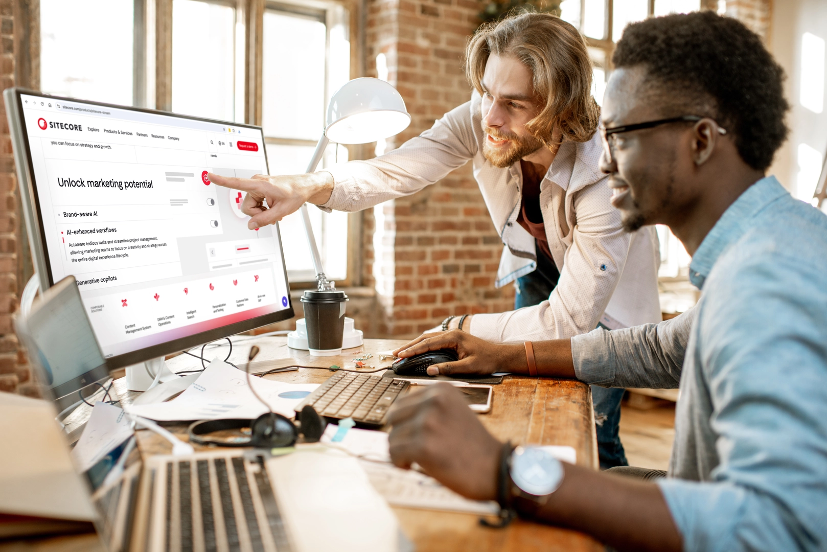 two men talking in office, one of the man pointing computer screen 
