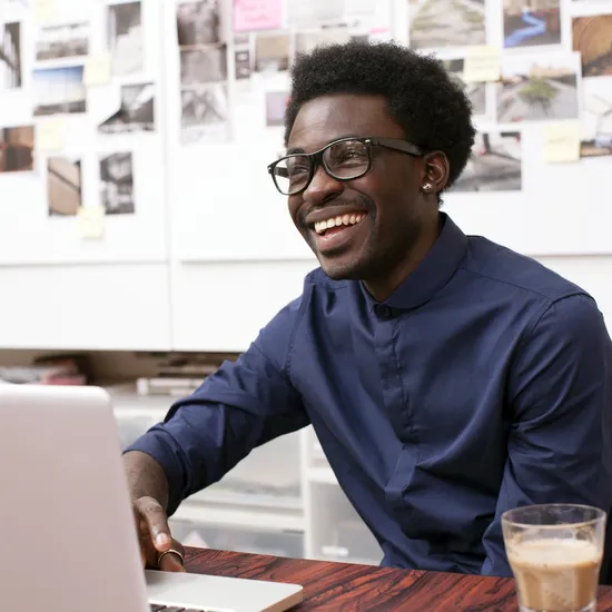 A young man working at his desk in a creative office environment - corporate business - laptop computer