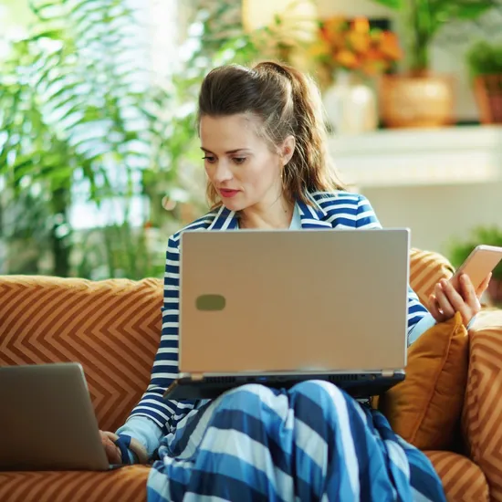 housewife in modern house in sunny day using devices 