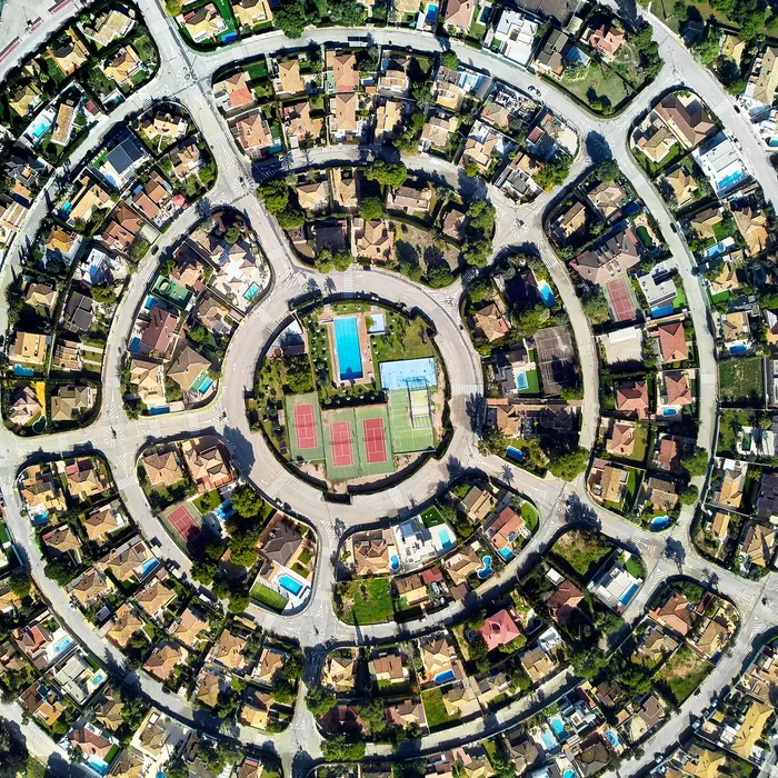 Aerial drone photography residential district Campoamor in the Costa Blanca, view directly from above symmetric round shaped, in the center of circle swimming pool and tennis courts. Alicante Province, Spain