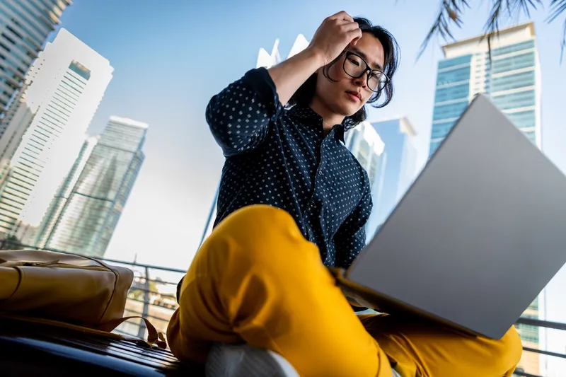 Woman outside with a laptop on her lap