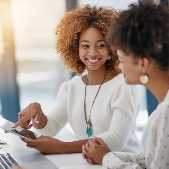 Shot of two smiling young entrepreneurs working on a laptop in their office