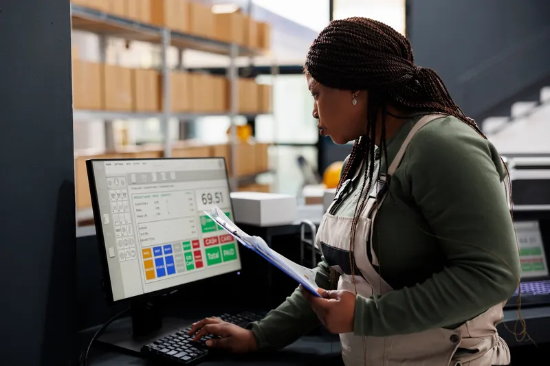 African,American,Worker,Looking,At,Inventory,Report,On,Computer,,Working