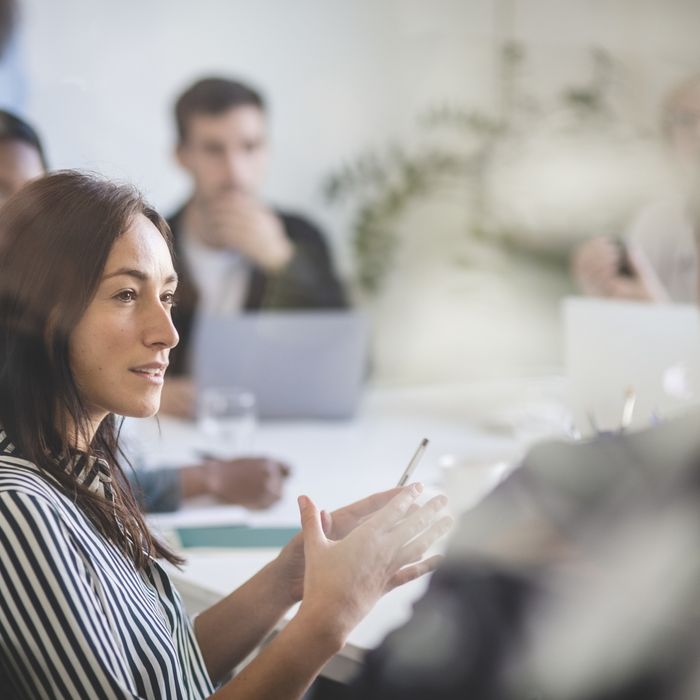 Businesswoman explaining colleagues during brainstorming session in creative office