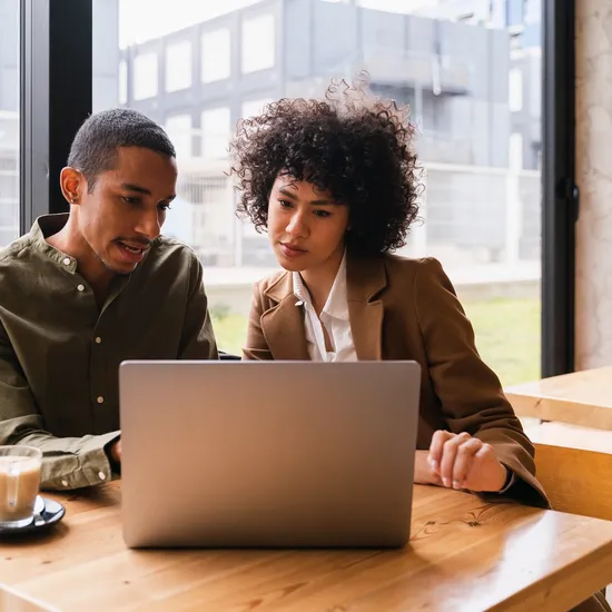 Two people at work looking at a laptop