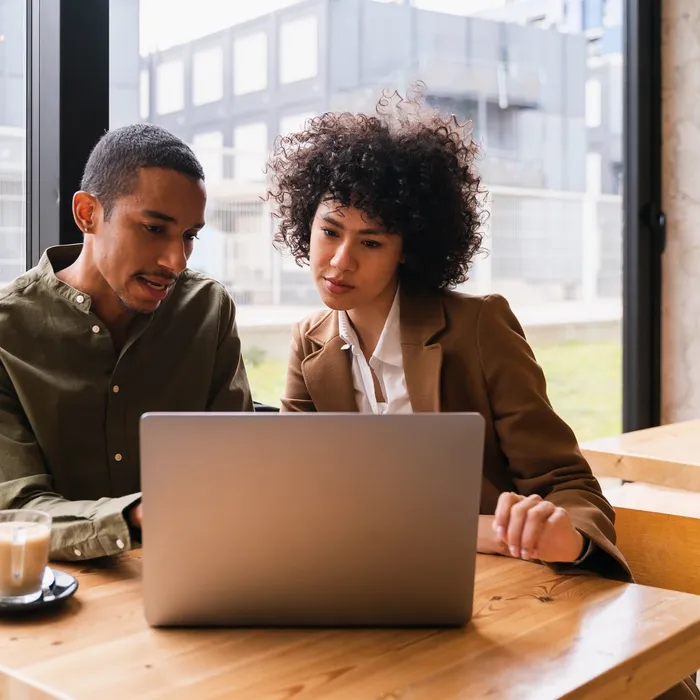 Two people at work looking at a laptop