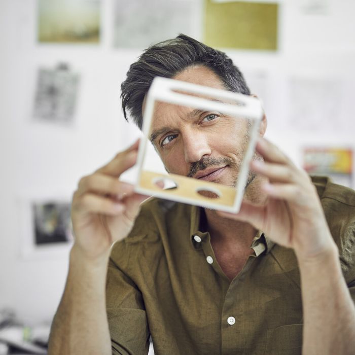 Portrait of man checking component in his office