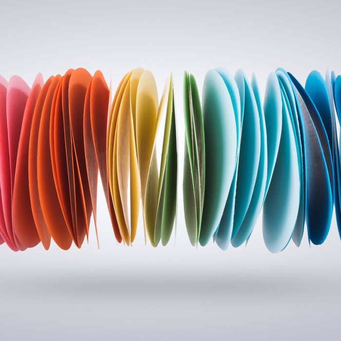 Stack of Colorful Papers in Mid-air on Grey Background.