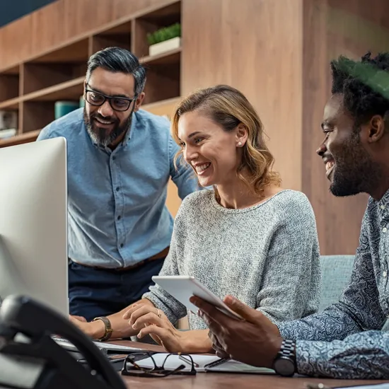 Casual businessmen and cheerful business woman in office working on a project together. Happy business man and colleagues working in a creative company. Mature businesswoman with her team working together on presentation for business meeting in office.