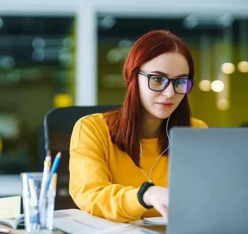 woman in yellow shirt working on computer 