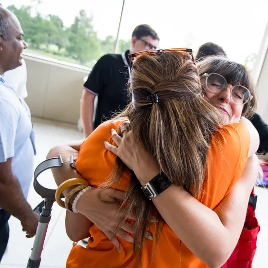 smiling woman hugs other women