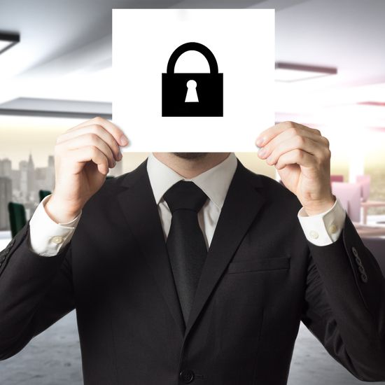businessman in modern office hiding face sign lock symbol