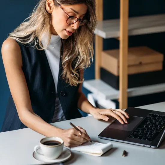 Woman at a desk writing in a book