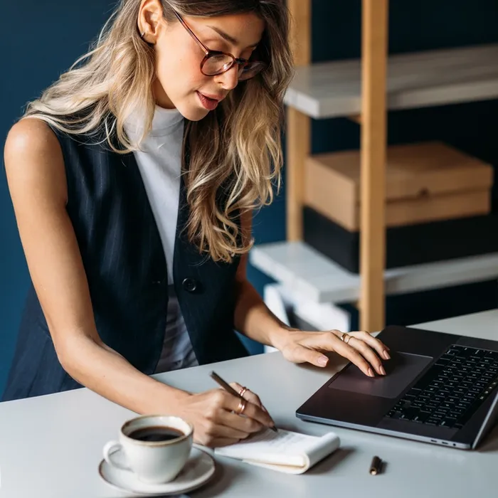 Woman at a desk writing in a book