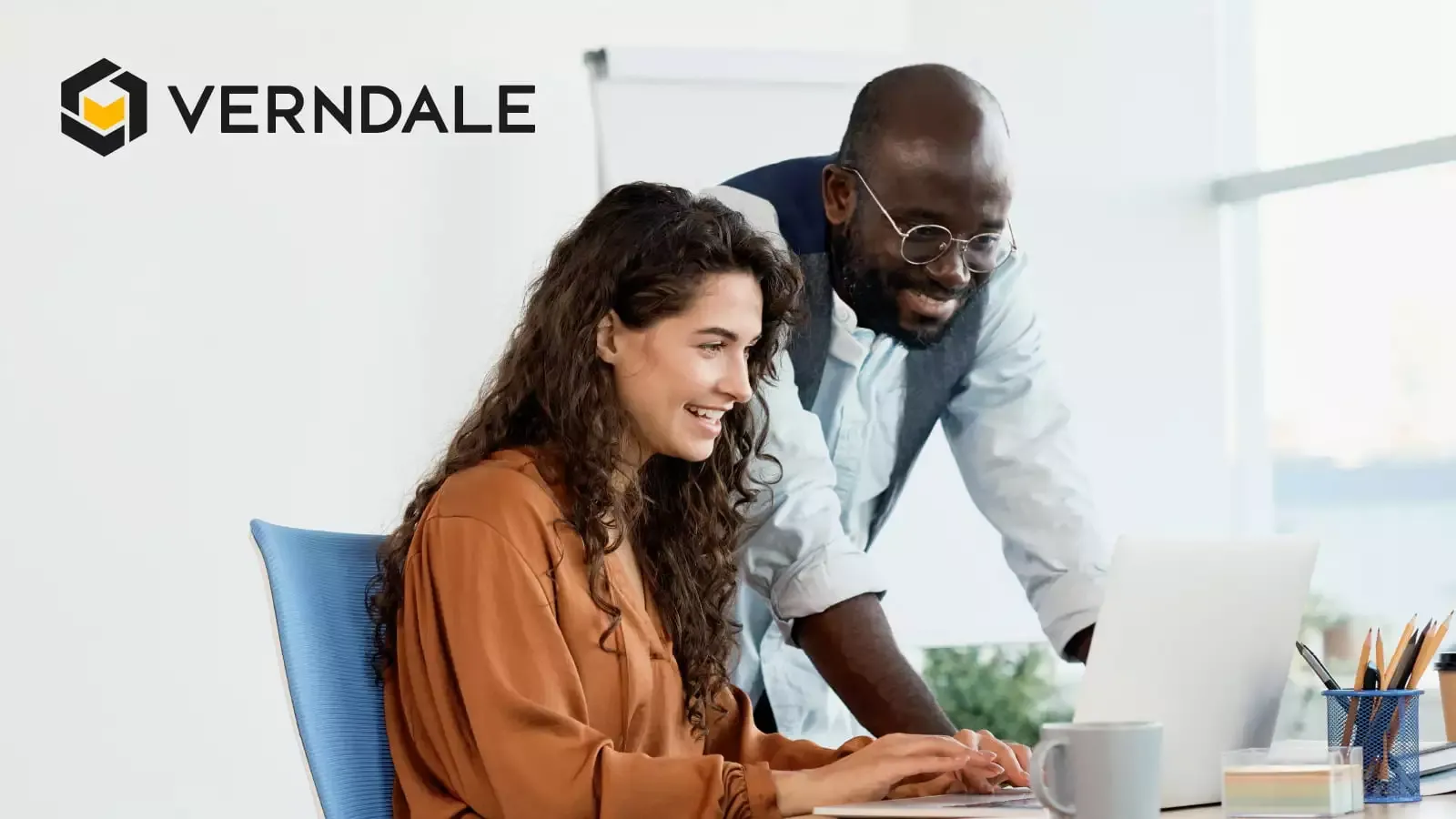 Man and woman looking into laptop and smiling