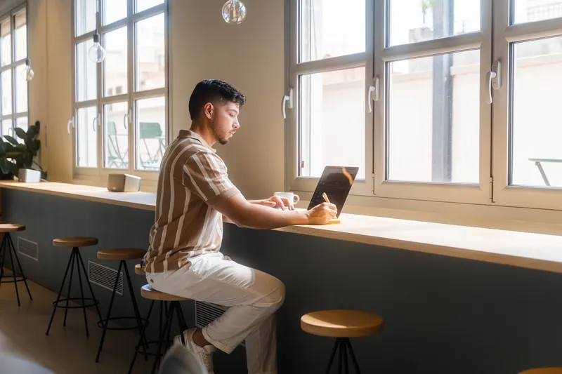 Man at a cafe working on a laptop