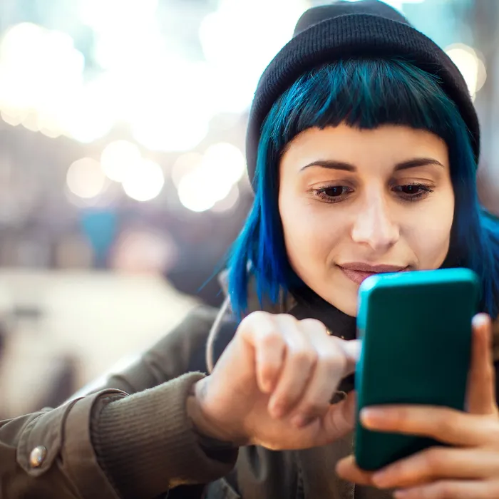 Girl with blue hair using smartphone