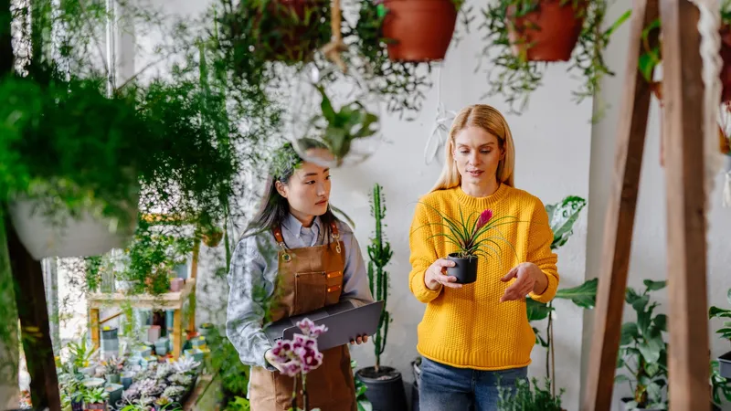 Sustainable,Greenery,Consult.,Female,Asian,Shopkeeper,With,Notebook,Amid,Lush