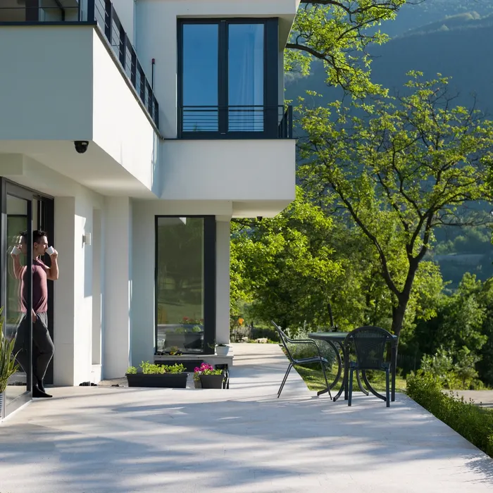 portrait of a young successful man drinking coffee in the doorway of his luxury home villa