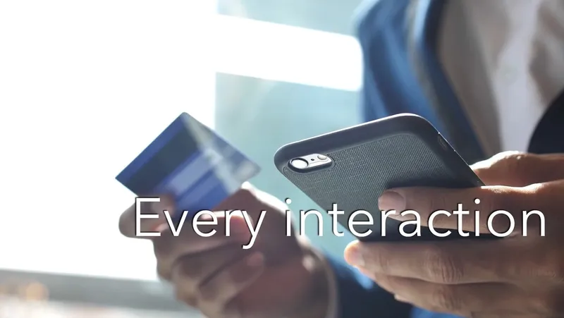 a screenshot of hands holding a credit card and a phone