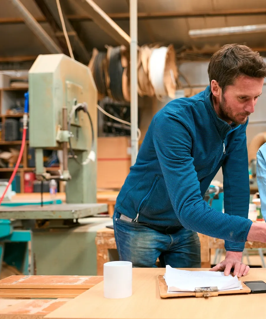 Male,And,Female,Carpenters,Working,In,Woodwork,Workshop,Using,Laptop