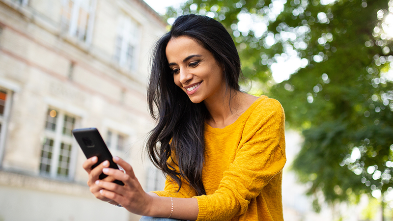 Woman looking at a smartphone and smiling