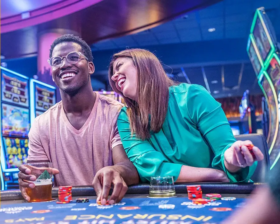 smiling man and woman playing poker and drinking liquor