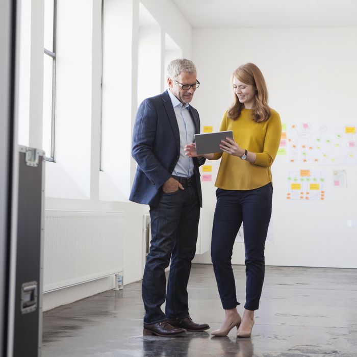 Businessman and coworker discussing project in office