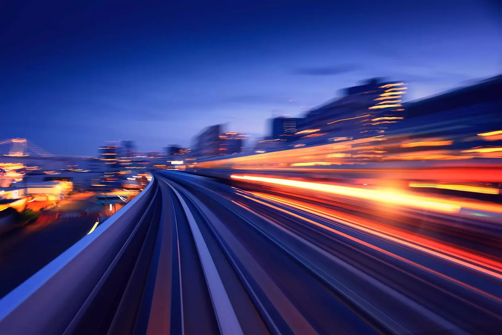 A blurred train moving through a bustling cityscape