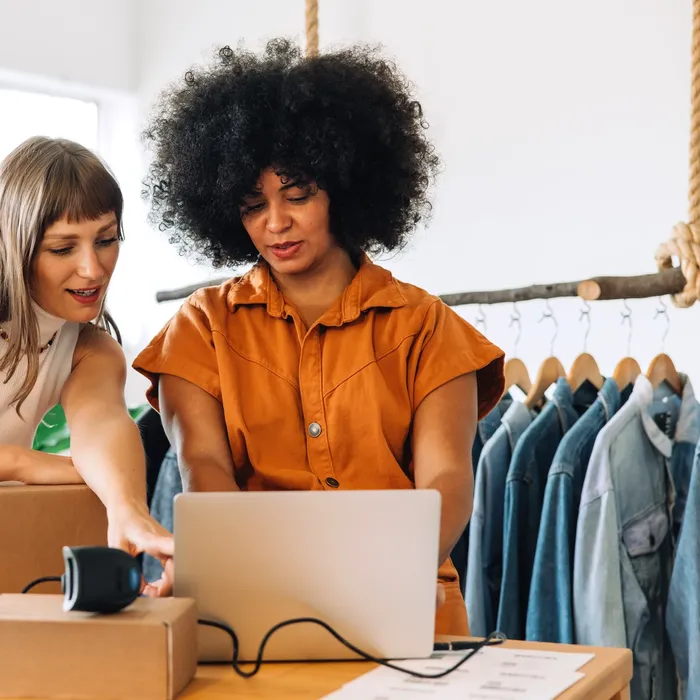 Thrift,Store,Owners,Having,A,Discussion,While,Using,A,Laptop