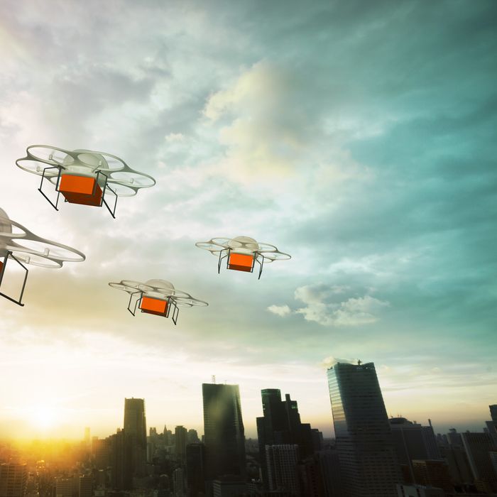 Five delivery drones flying above the city at sunset