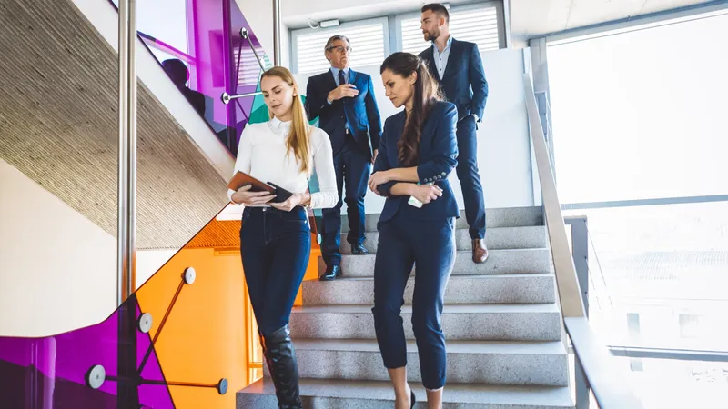 A group of business people walking down the stairs, all wearing elegant business clothes and holding some documents while walking, hard work always pays off, coworkers manage business and finance industry.