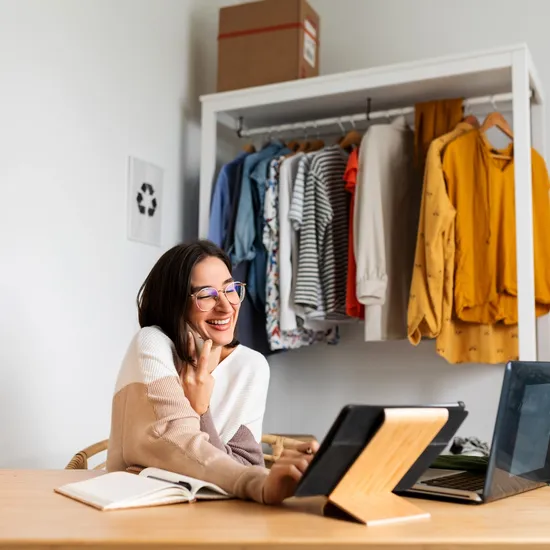 Woman in front of a rack of clothes using a POS system