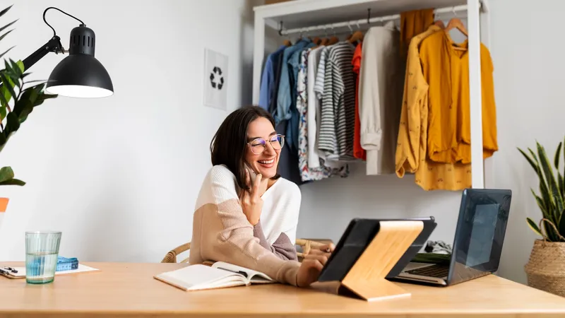 Woman in front of a rack of clothes using a POS system