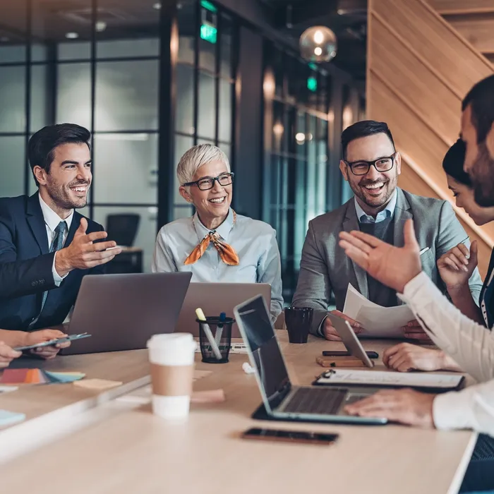 Mixed group of business persons sitting around the table