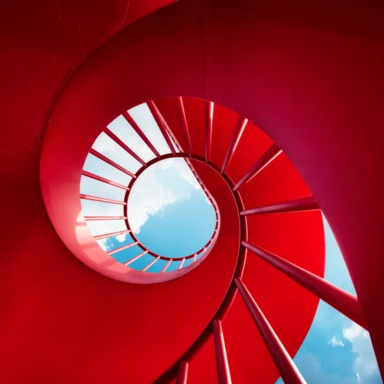 Red spiral staircase against skyColorful Human