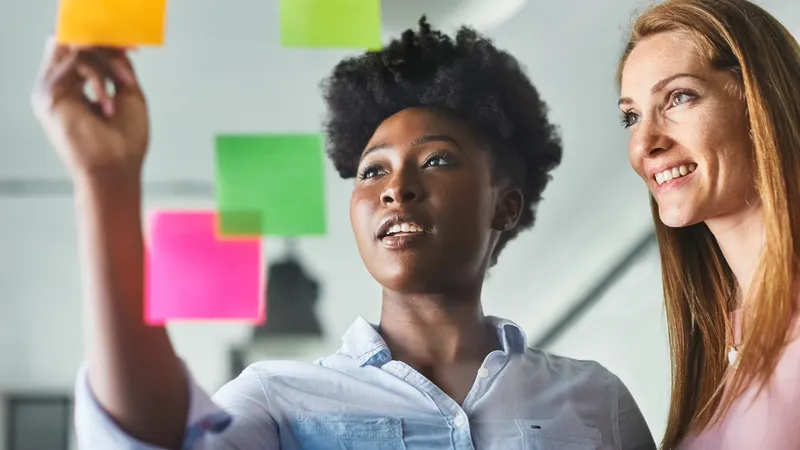 Business people meeting at office and use post it notes to share idea. Brainstorming concept. Sticky note on glass wall.