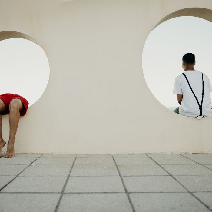Two young men sitting in circles in a wall